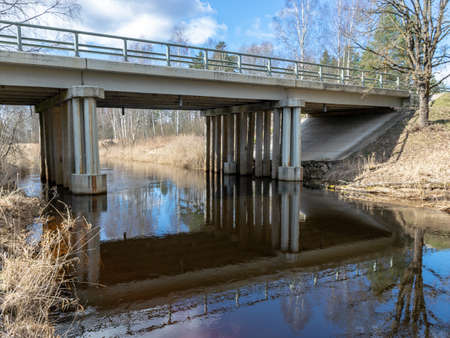 sunny spring landscape with a bridge over the river Seda, Latviaの写真素材