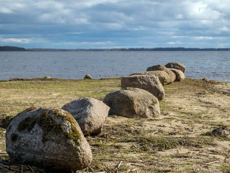 row of stones on the shore of the lake, Lake Burtnieki, Latviaの写真素材