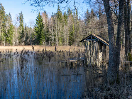 view of lake shore in early spring, fisherman's wooden hut by the water's edgeの写真素材