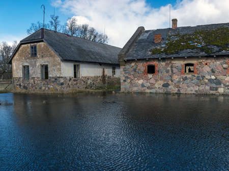 landscape with old stone houses, water reflections in the foreground