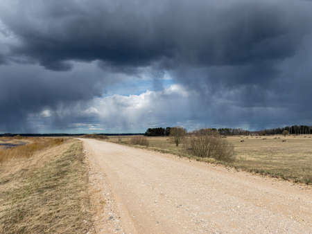 simple rural landscape with a rural road, beautiful cumulus clouds, Silzemnieki meadows, Burtnieki, Latviaの写真素材