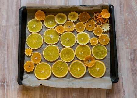 picture with sliced orange slices on a metal pan preparing for drying, preparing for Christmas,...