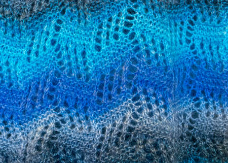 Close-up background image of a variegated knitted blanket with a colorful graphic design, crocheted,...