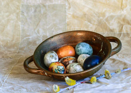 ancient copper bowl with colored eggs, celebration of Easter, still life