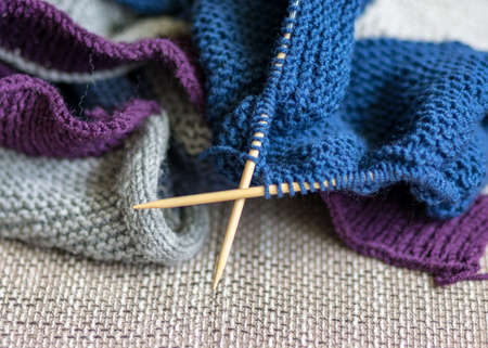 picture with knitted sweater, knitting needles and yarn, close-up view