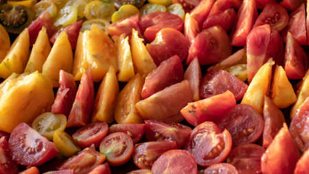 tray with sliced tomatoes, different colors and shapes, autumn harvest time