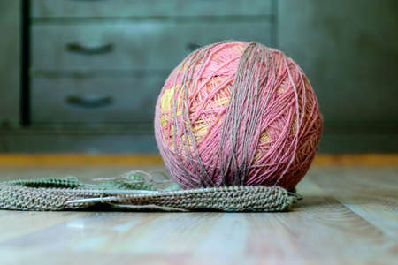picture with variegated color balls on the knitted textile background, wool yarn and knitting tools...