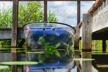 landscape with a transparent plastic boat, exploring a wild lake, summer recreation in natureの写真素材