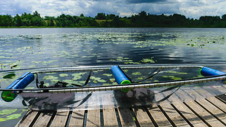 landscape with a transparent plastic boat, exploring a wild lake, summer recreation in natureの写真素材
