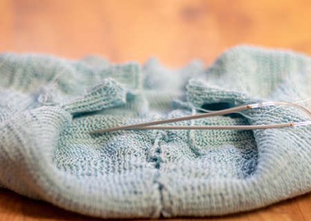 picture with light blue cotton sweater, knitting close-up, handmade, knitting as a hobby