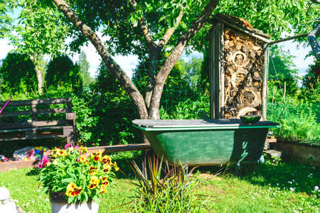 Scenic view of beautiful garden, colorful flowers in pots, home hobby still life with garden objects and nature, garden in summer with flowers and plants and decorationsの写真素材