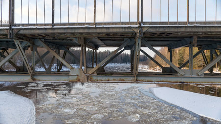 landscape with a river in winter, in the backlight of the bridge structure
