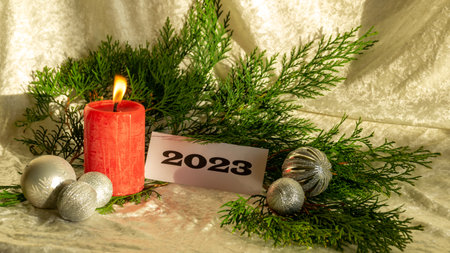 Christmas decorations on light background, red candle and text 2023, Happy New Year and Merry...