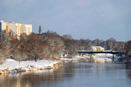 winter landscape with river and snow-covered trees on the river bank, Valmiera, Latviaの写真素材