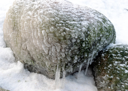 different ice formations on rocks on the seashore, ice texture, wind, water and ice working together, winter by the seaの写真素材