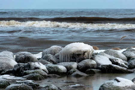 different ice formations on rocks on the seashore, ice texture, wind, water and ice working together, winter by the seaの写真素材