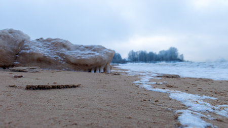different ice formations on rocks on the seashore, ice texture, wind, water and ice working together, winter by the seaの写真素材
