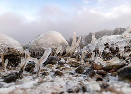various ice formations on rocks and sandbars on the seashore, ice texture, wind, water and ice working together, winter by the seaの写真素材