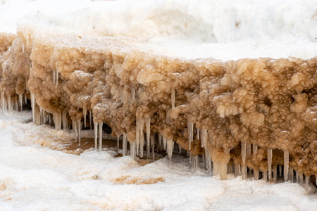lying pieces of ice on the seashore, icicles of different sizes, textures of sand and ice in the dunes, Baltic Sea, Latvia in winterの写真素材