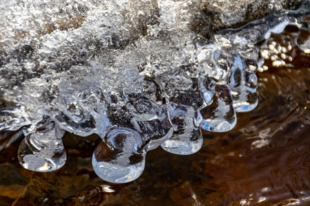 water and ice formations in the river, frozen ice drops, winter by the river.