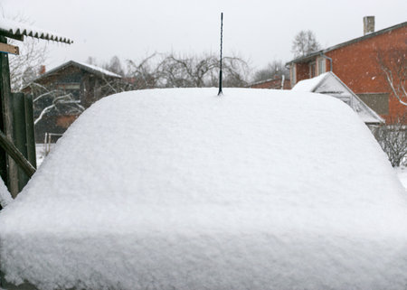 fresh snow covers the surroundings and the car, abstract snow texture on a metal surface, winterの写真素材