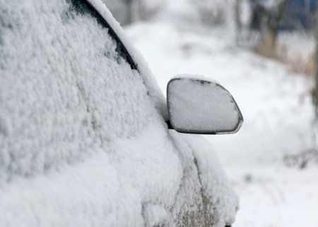 fresh snow covers the surroundings and the car mirror, snow texture on a metal surface, winterの写真素材