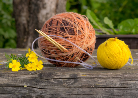 still life with a ball of yarn on an old wooden background, beautiful texture, fuzzy background, autumn colorsの写真素材