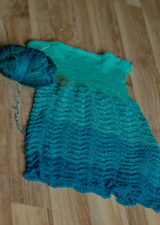 photography with a fragment of a blue knitted sweater of different shades, leisure concept, handmade
