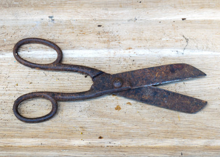photo with antique iron scissors on wooden background, rusty tools, metal waste, scrap metal