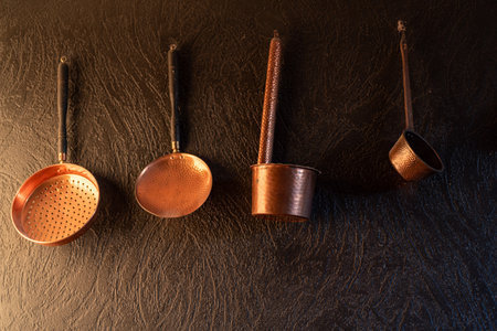 beautiful capers, copper dishes on a black wall, decorative kitchen interior items, decorative dishesの写真素材