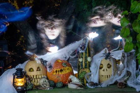 scary Jack O Lantern Halloween pumpkins in the dark, carved pumpkins with different scary faces surrounded by a ghost face in the background, Halloween decoration sceneの写真素材