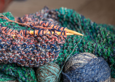 unfinished knitting, skeins of colored woolen yarn, needlework concept, ball of woolen yarn, wooden...