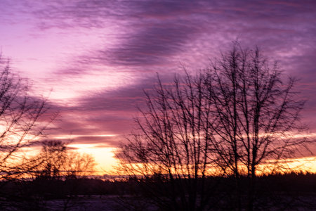 colorful sunrise sky outside the window, colorful play of light, shadows and reflections on the window glass, blurred outlines, winterの写真素材