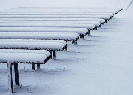 winter landscape with rhythmic rows of wooden benches on the lake shore, open-air stage, mottled texture, Vaidava, Latvia, winter dayの写真素材