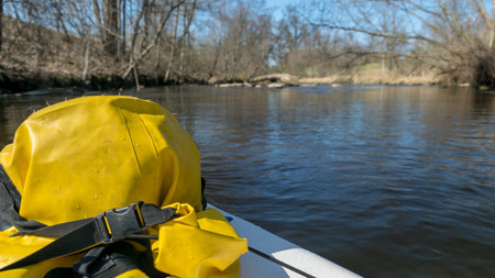 landscape with a yellow waterproof bag in the foreground on a paddle board, in the background a view...