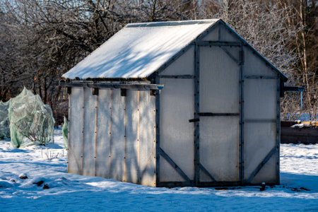 wonderful winter day, trees and grass covered with frost, film greenhouse in the garden, winterの写真素材