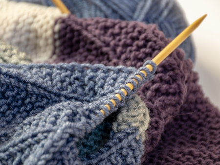 Close up wool colored knitting gold needle, kniting woolen texture, grey ball of woolen yarn with...
