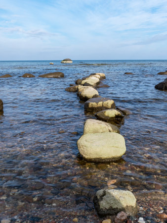 blue seascape with many stones on a sunny day, Kaltene sea shore, Latviaの写真素材