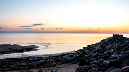 Magical sunset by the sea, the last rays of the sun are reflected in the calm sea surface, bright colors, Vidzeme seaside, Latviaの写真素材