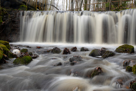 A long exposure view of a waterfall in a small rapid river, autumn landscape, November in nature,...