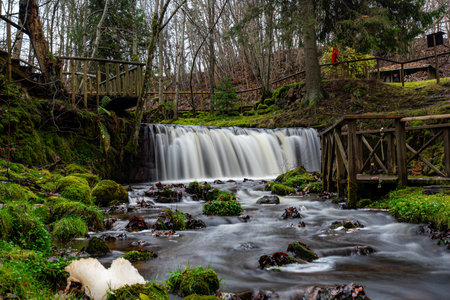 A long exposure view of a waterfall in a small rapid river, autumn landscape, November in nature, Ieriku mill, Melderupe, Latvia, fallの写真素材