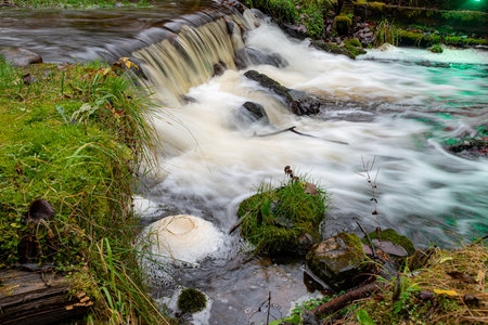 A long exposure view of a waterfall in a small rapid river, autumn landscape, November in nature, Ieriku mill, Melderupe, Latvia, fallの写真素材