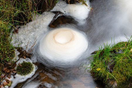 a long exposure view of a small fast river, beautiful water formations, autumn landscape, november in nature, fallの写真素材