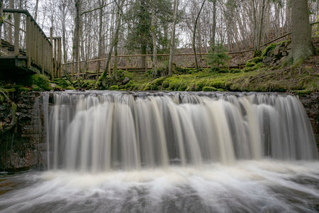 A long exposure view of a waterfall in a small rapid river, autumn landscape, November in nature,...