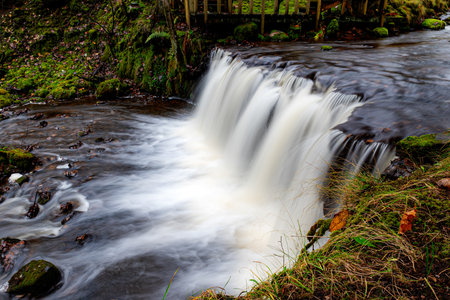 A long exposure view of a waterfall in a small rapid river, autumn landscape, November in nature, fallの写真素材