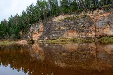 beautiful view of sandstone outcrops on the riverbank, autumn landscape, reflections in the river, Gauja, Erglu cliffs, Latviaの写真素材