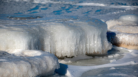 Wonderful view of the frozen sea coast in winter, pieces of ice of different sizes, ice-covered...