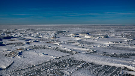 Wonderful view of the frozen sea coast in winter, pieces of ice of different sizes, bright blue...