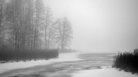 foggy spring landscape with a frozen river, blurred tree outlines in the background, damp and cloudy spring, Latviaの写真素材