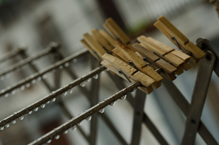 Lines of waterdrops and wooden clotherpins after the rainの写真素材